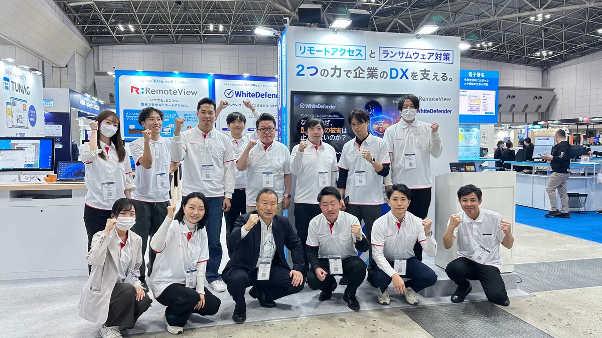Japan DX Week 2026 春での、RSUPPORT株式会社スタッフ一同の集合写真。お揃いの白いポロシャツでガッツポーズ。