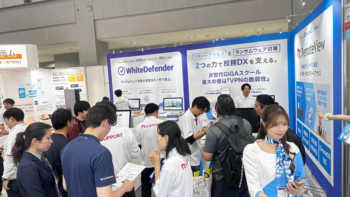 EDIX東京のブースで、Chromebookから校務PCへの画面転送デモを熱心に見る教育関係者。
